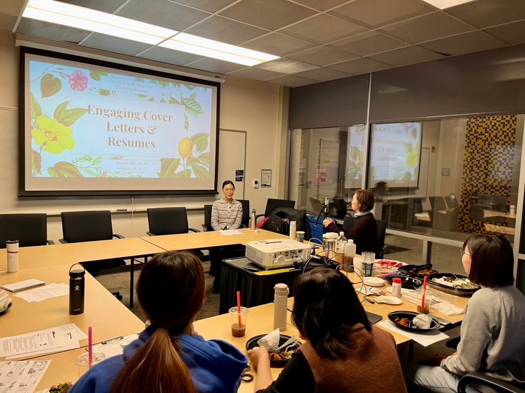 Doreen Hsu providing an educational workshop on engaging cover letters and resumes as Dr. Write-Aid. Food and drinks are laid on the table with the Powerpoint slides shown on the screen behind her. Participants sit around the table. Doreen Hsu providing an educational workshop on engaging cover letters and resumes as Dr. Write-Aid. Food and drinks are laid on the table with the Powerpoint slides shown on the screen behind her. Participants sit around the table.